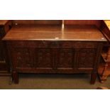 An 18th century oak four-panel coffer with stylised foliate carving, 170cm by 52cm by 70cm