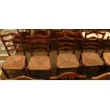 A set of four early 19th century elm ladder back rush seated chairs