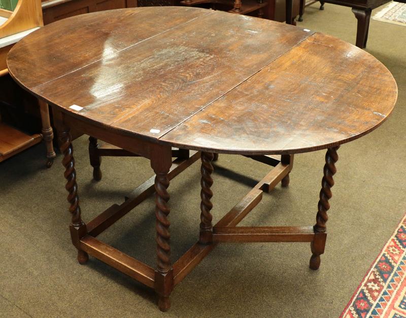 An early 20th century oak barley twist gate-leg dining table, 141cm by 108cm (open) by 73cm