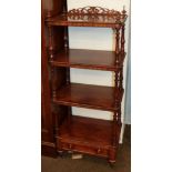A Victorian mahogany four-tier whatnot stand with fretwork pediment, turned supports and a single