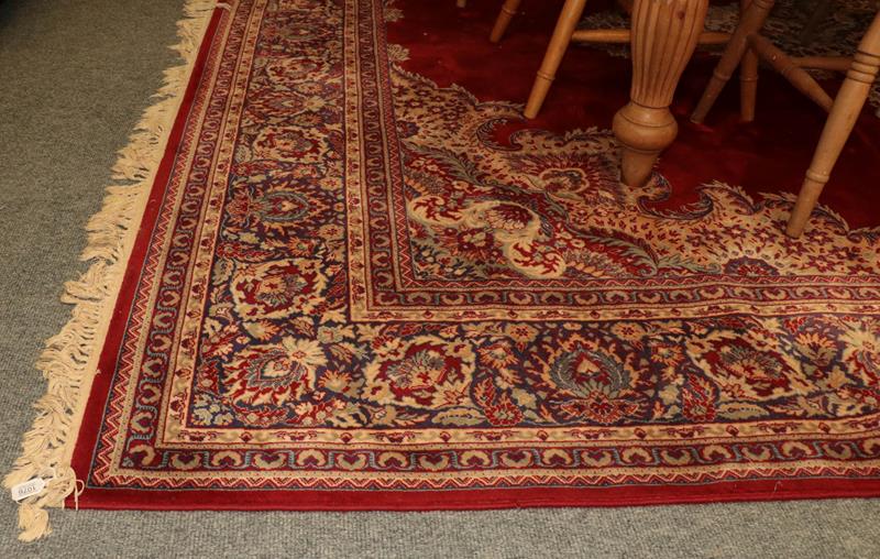 Machine made carpet of oriental design, the blood red field with central medallion framed by