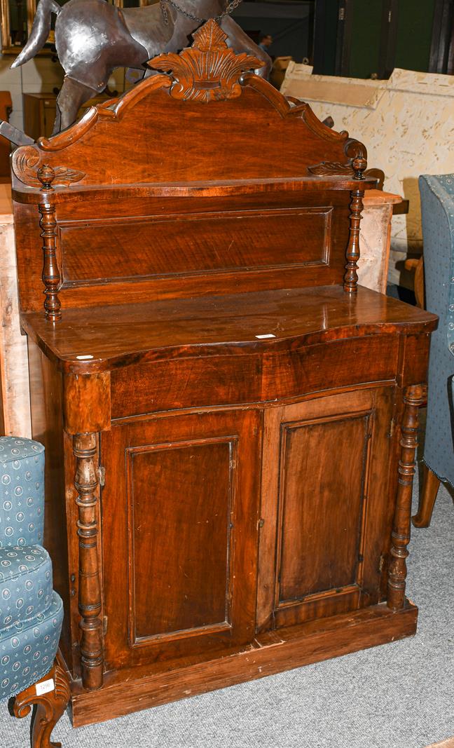 An early 20th century mahogany chiffonier of serpentine form, with turned supports, 87cm by 40cm