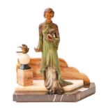 An Art Deco French spelter group, modelled as a young woman in a green and silver dress holding a