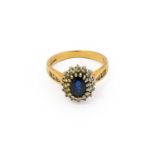 A 9 carat gold sapphire and diamond cluster ring, the oval cut sapphire within a border of eight-