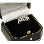 A diamond cluster ring, the buckle motif set throughout with round brilliant cut diamonds, in