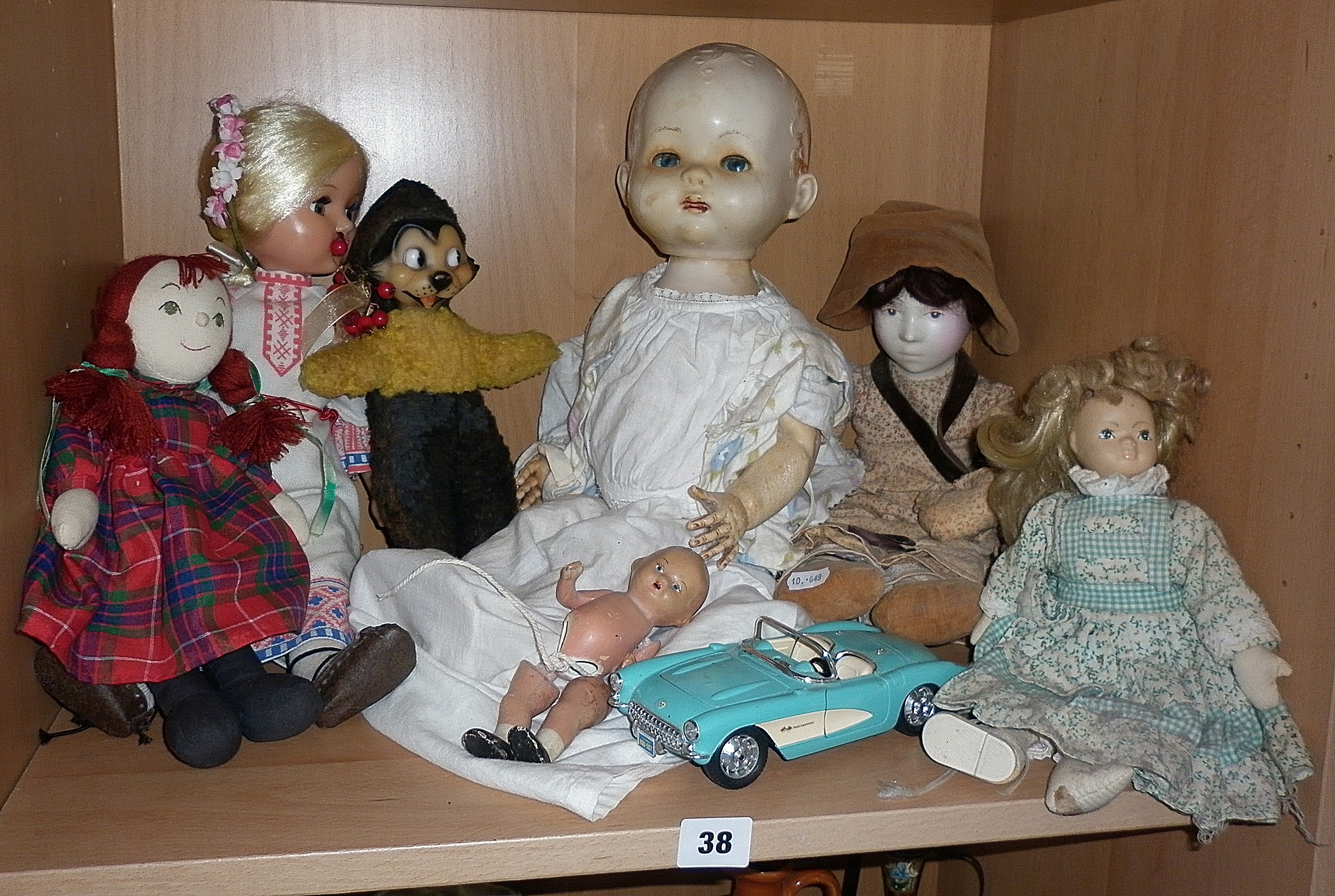 Group of seven assorted old dolls and a Die-cast Chevrolet Corvette car