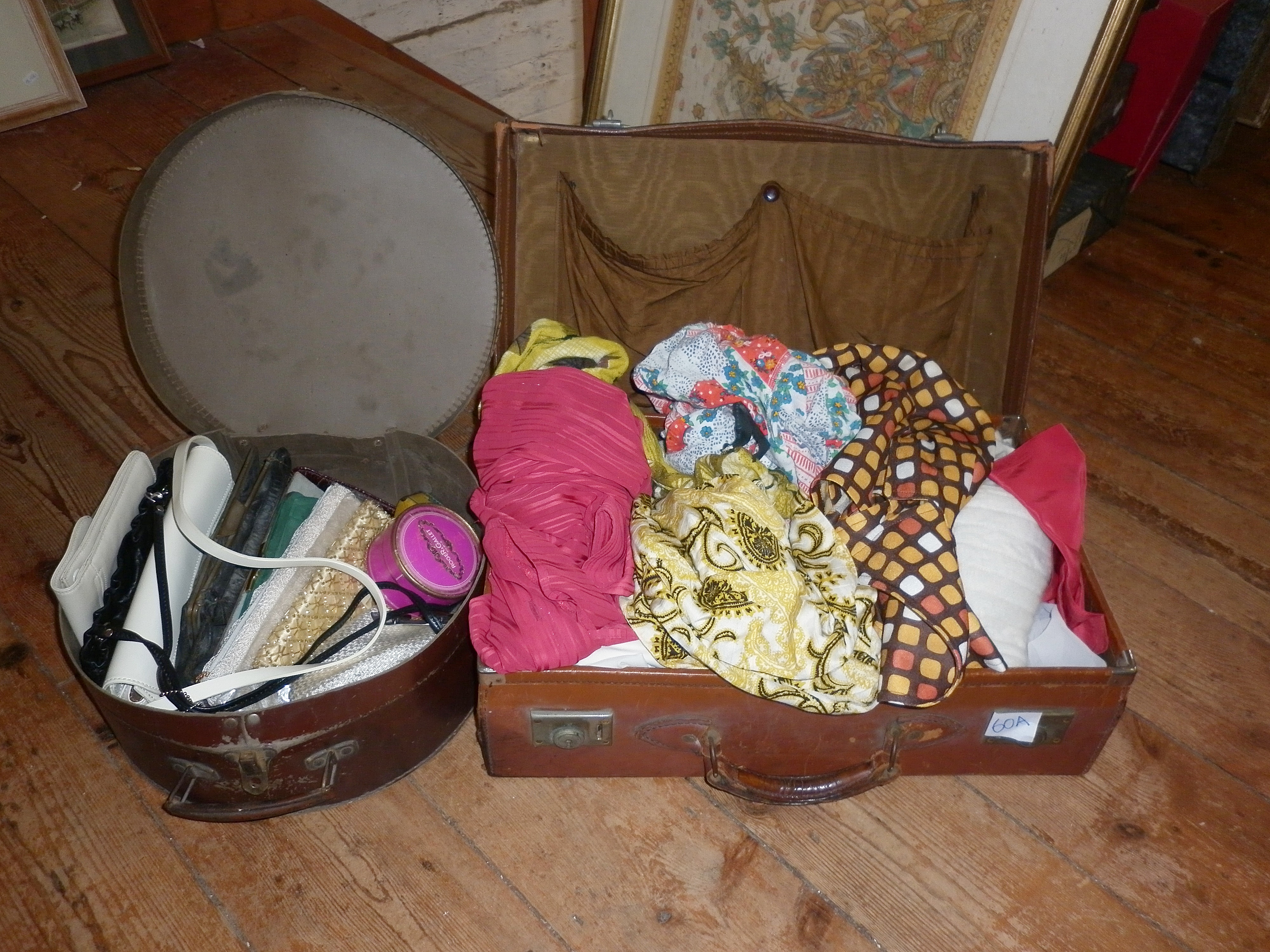 Leather suitcase containing vintage clothing and a hat box of handbags