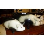 Large and smaller black and white pottery piggy banks