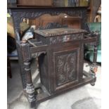 Victorian carved oak stickstand with single drawer above cupboard flanked by turned columns