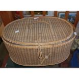 Oval lidded wicker basket with fitted interior