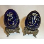 Two engraved Russian blue glass eggs on gilt stands