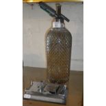 1920's barware: Soda syphon with wire mesh cover and a chrome and steel Ensign Universal splicer