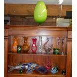 Two shelves of assorted coloured glass vases, baskets and a large Murano pike fish, etc.