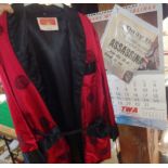 A Chinese red and black silk smoking jacket and a 1953 TWA Airlines calendar together with a 1963