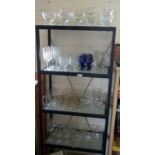 Four shelves of assorted drinking glasses and sundae dishes
