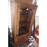 An oak cupboard with bevelled glass door
