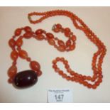 Art Deco banded agate necklace with large cherry amber bead, and another necklace similar