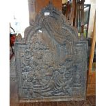 An arch topped cast iron fireback with relief figurative decoration, c.1910