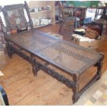 19th c. carved oak daybed with carved Cupid to back & having cane-work seat upon barley-twist