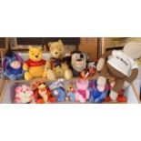 Collection of branded soft toys on two shelves, including Disney Pooh Bears, Tigger and Taz from