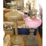Victorian oil lamp with pink opaque glass reservoir and a brass column oil lamp base