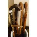Bundle of walking sticks, inc. African hardwood and a horn handled riding crop with silver collar,