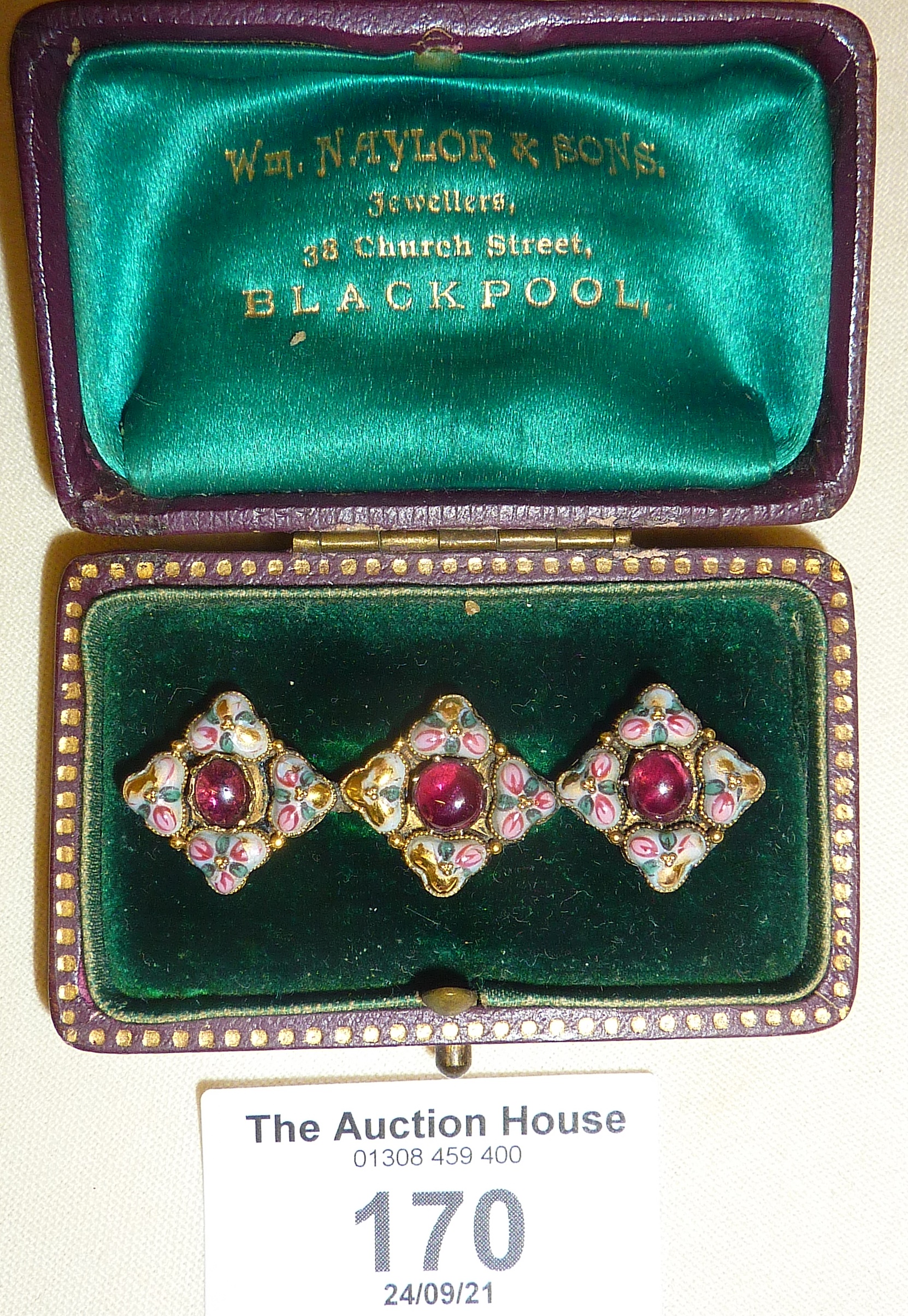 Georgian gold brooch in case, set with red stones and enamelled porcelain (some chips)