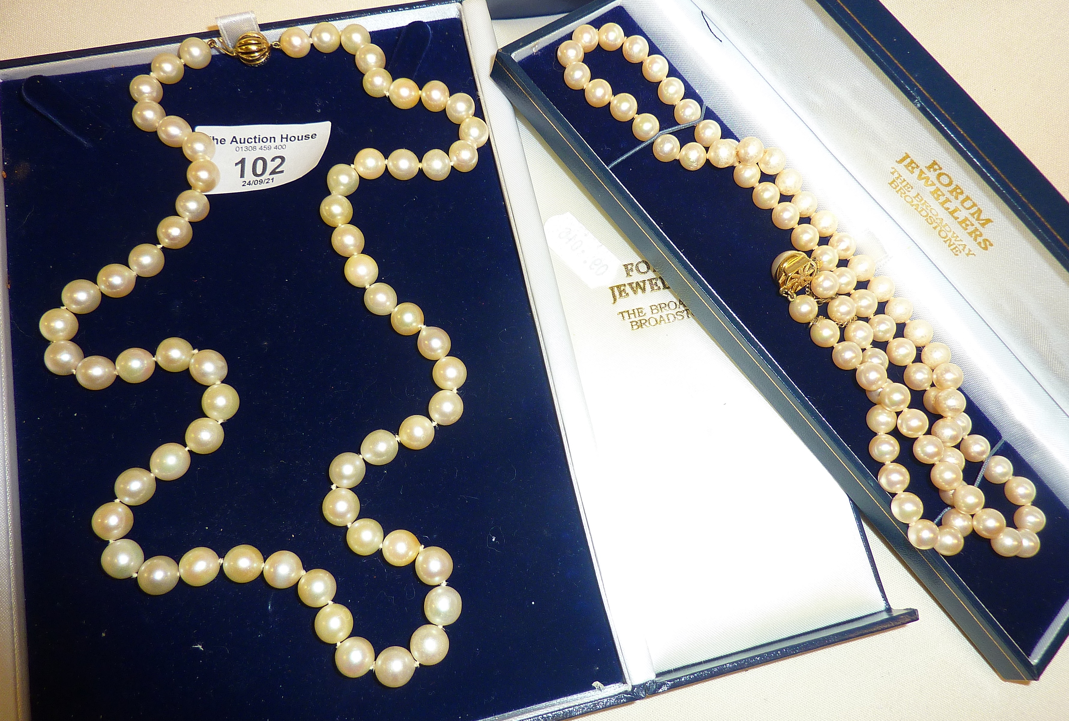 Pearl necklace in case with 9ct gold clasp, approx. 24.5" long. Together with another (faux