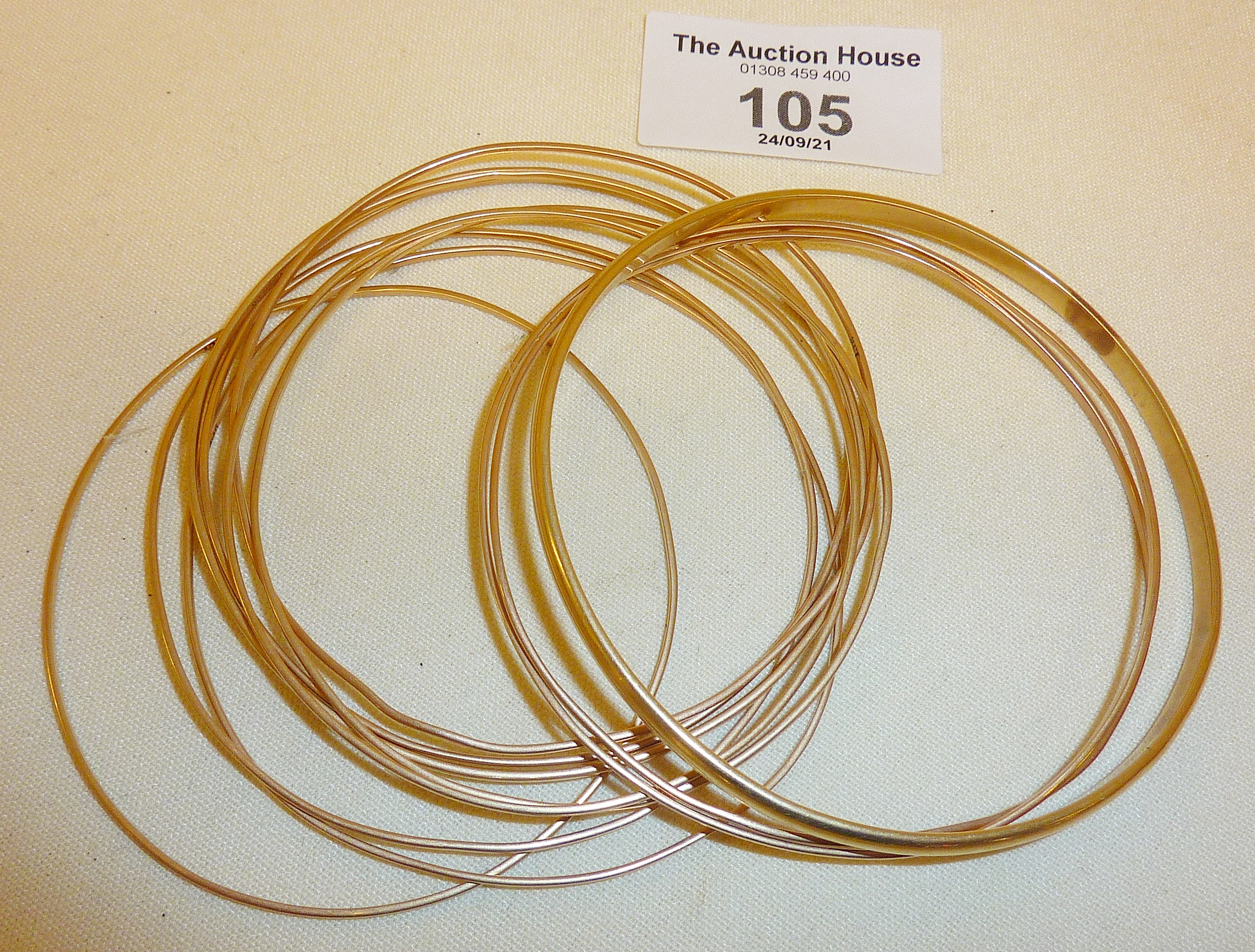 Eleven 9ct gold bangles (one marked, the rest untested), approx. 32g. in weight