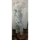 Tall glass trumpet shaped lily vase on wood plinth