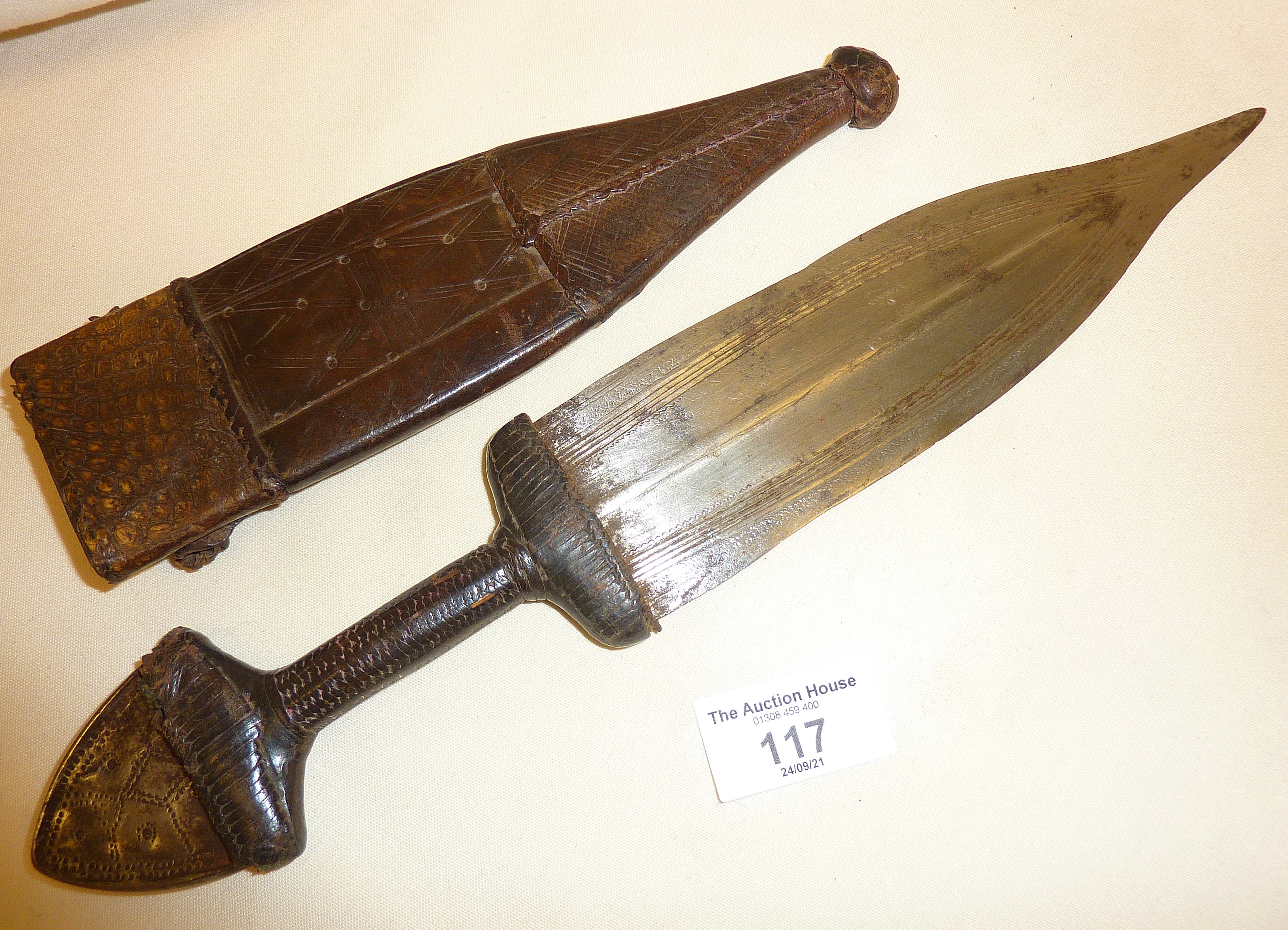 Tribal Art: An African dagger in a leather sheath, engraved decoration to the blade and pommel - Image 2 of 2