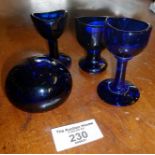 Three antique Bristol blue glass eye baths and similar paperweight