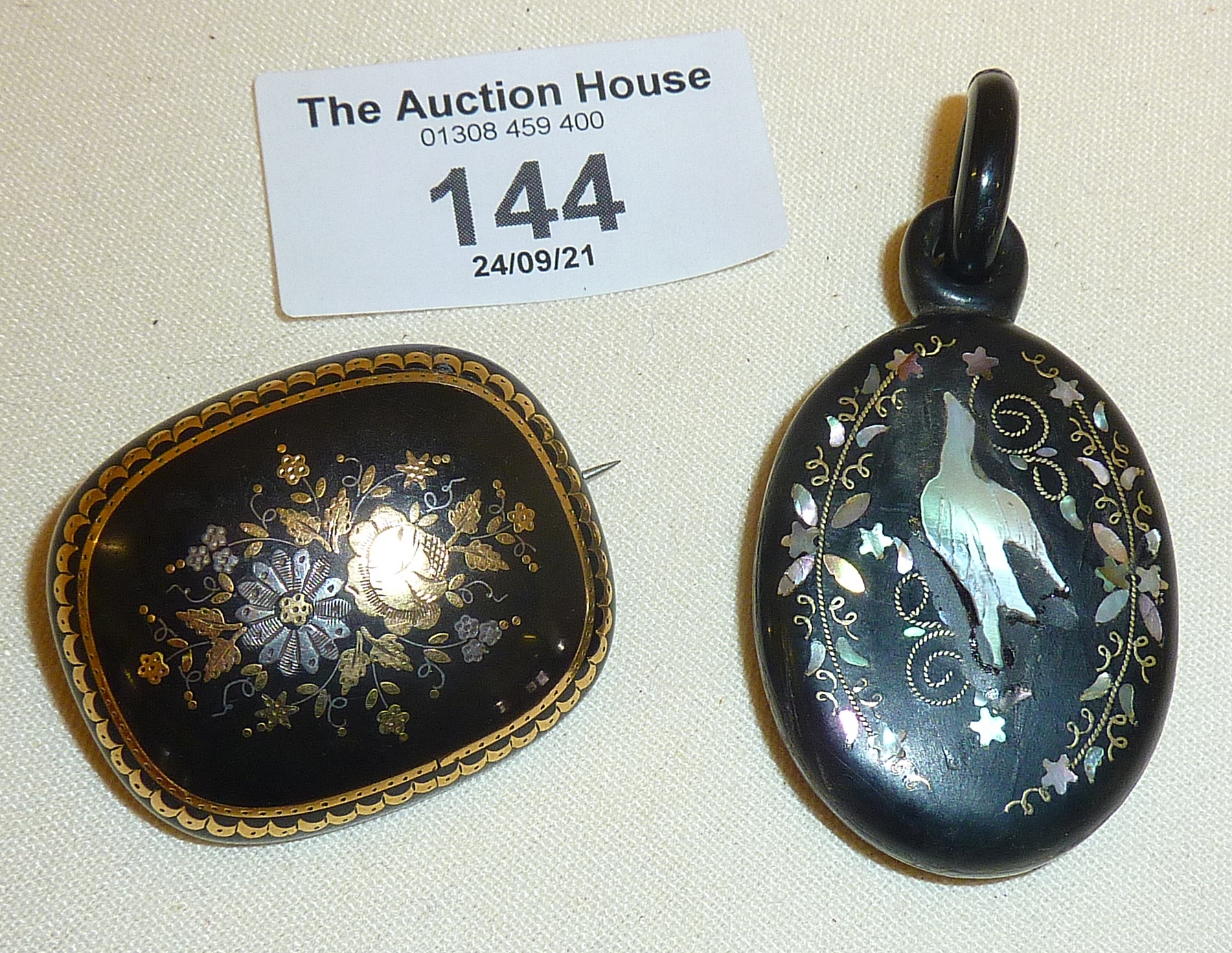 Victorian jet mourning pendant inlaid with mother of pearl, and a tortoiseshell brooch with fine