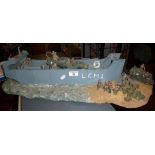Model of D-Day landing craft with vehicles & soldiers embarking on a beach together with a parachute