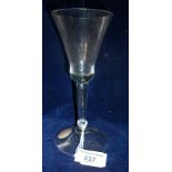 An early 18th c. baluster wine glass with bell bowl on hollow clear stem on conical foot, 7" high