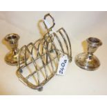 Sterling silver toast rack and a pair of silver weighted candlesticks. Toast rack hallmarked for