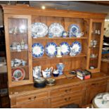 Pine kitchen dresser with upper section of shelves and glass fronted cabinets above four drawers and