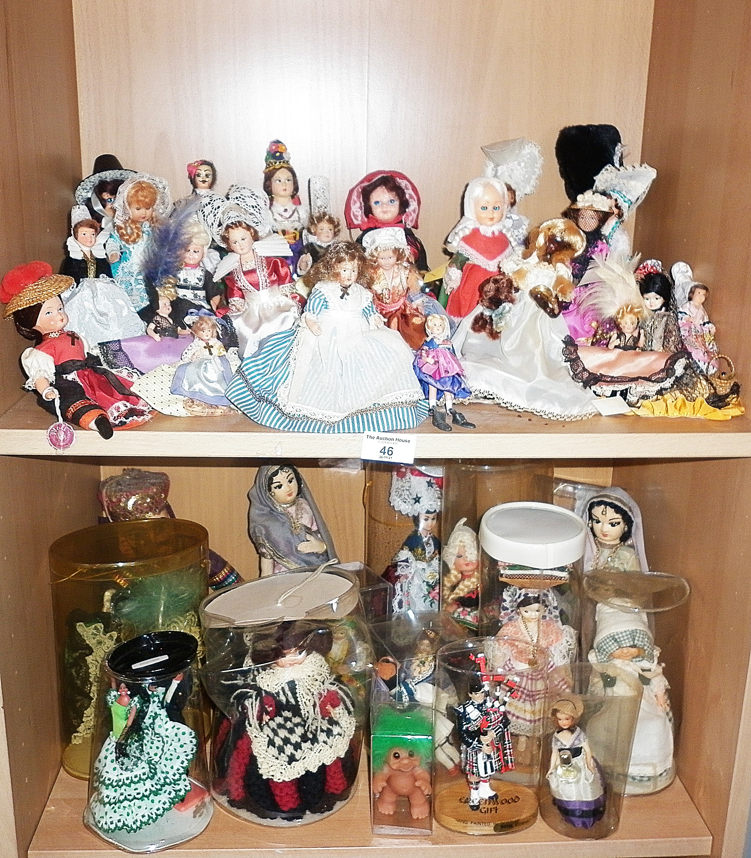 Collection on two shelves of dolls in national costumes
