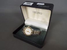 A lady's Seiko wristwatch, the dial surrounded by a border of white stones,