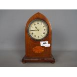 A mahogany cased lancet top mantel clock, Roman numerals to a white dial.