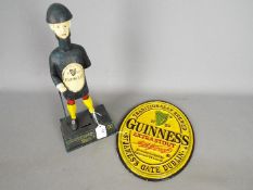 Breweriana - an oval, cast iron wall plaque and a money bank marked 'Guinness',