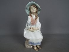 Lladro - A Lladro figurine entitled 'Daydreams' # 6400, depicting a young girl holding a dog,