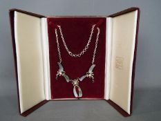A Silver necklace with garnet and pearl design