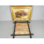 A framed needlework sampler with letters, numbers, biblical verse set between horizontal borders,