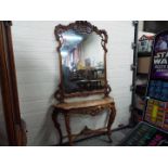 A highly carved console table with marble top and matching mirror,