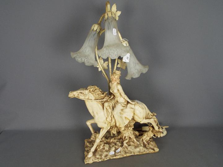 A decorative three stem table lamp in the form of a lady on horseback,