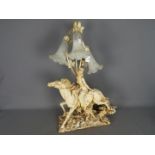 A decorative three stem table lamp in the form of a lady on horseback,
