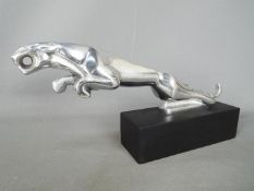 A chrome depiction of a Jaguar set on a base, 14.