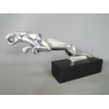 A chrome depiction of a Jaguar set on a base, 14.