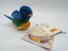 Steiff - a mohair Steiff blue bird entitled Lora with tag on breast, button and yellow label,